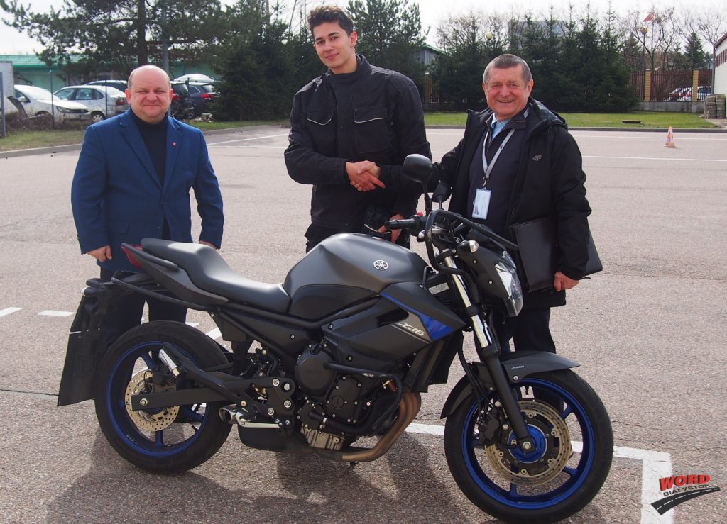 Rozpoczęcie sezonu egzaminacyjnego na kategorię A prawa jazdy Na zdjęciu stoją przy motocyklu osoba, która zdawała egzamin wraz z egzaminatorem i Dyrektorem Ośrodka