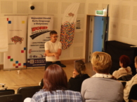 Zdjęcie z wydarzenia przedstawia wykładowcę oraz osoby biorące udział